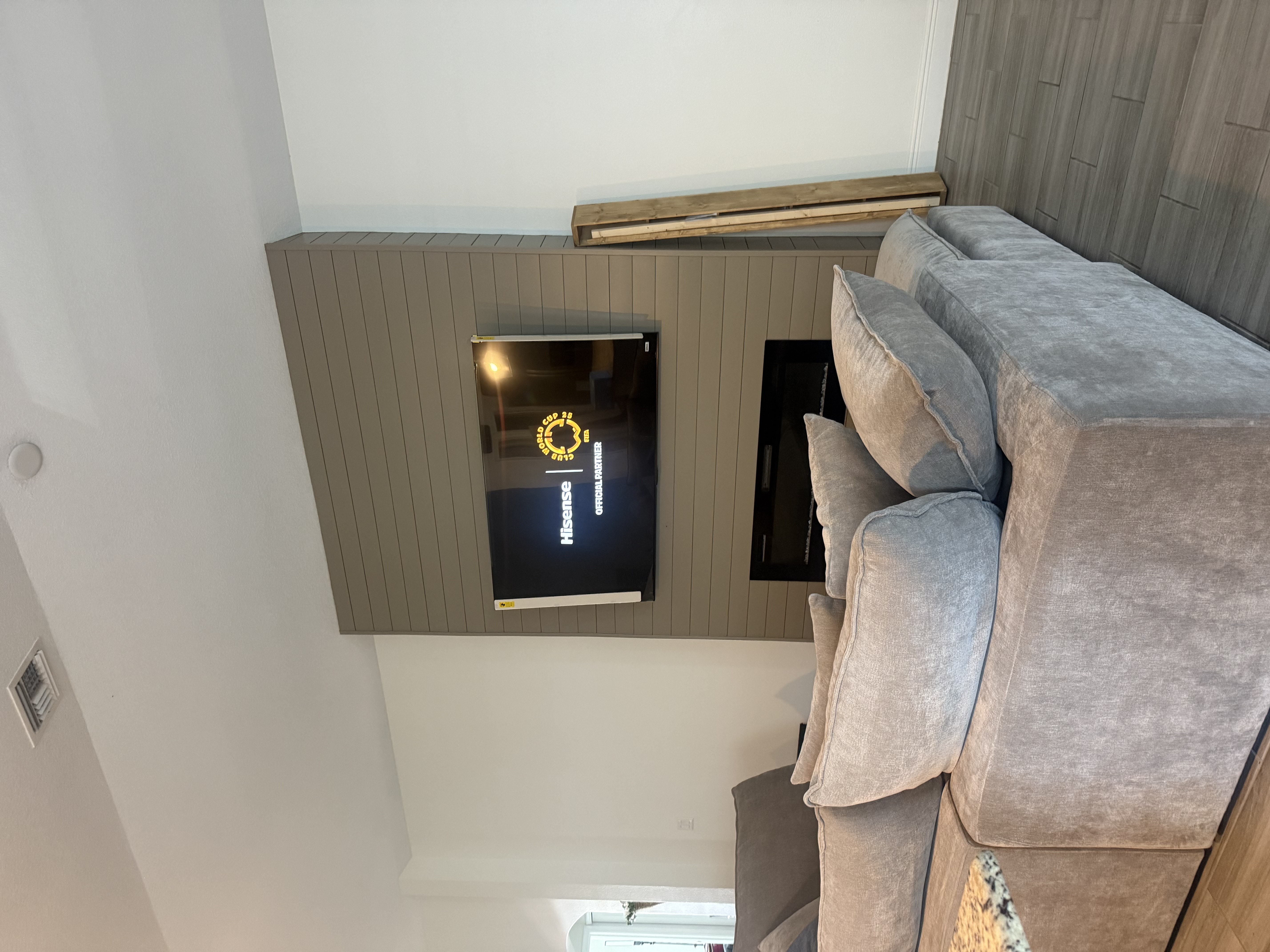 TV mounted on a shiplap accent wall above a fireplace